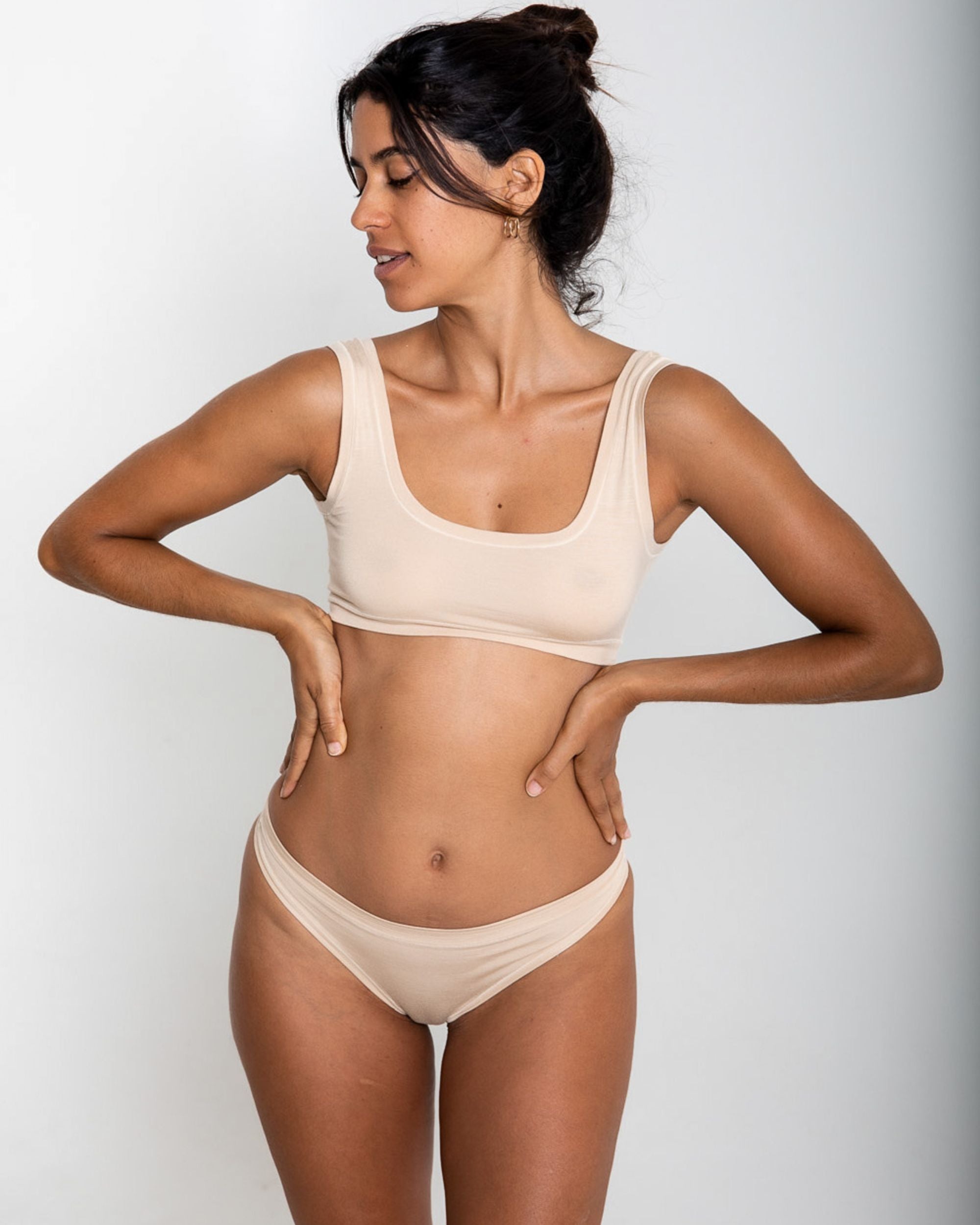 Woman wearing a beige underwear against a plain background