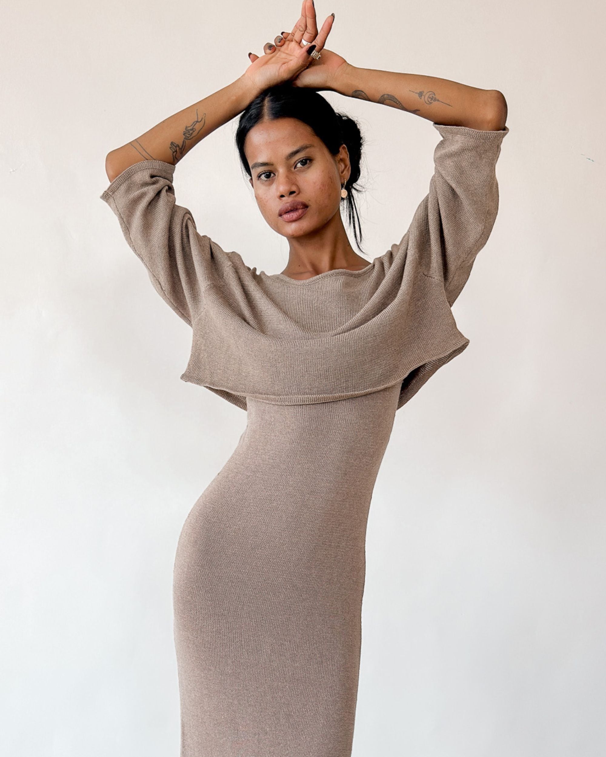 Woman wearing a beige dress against a plain background